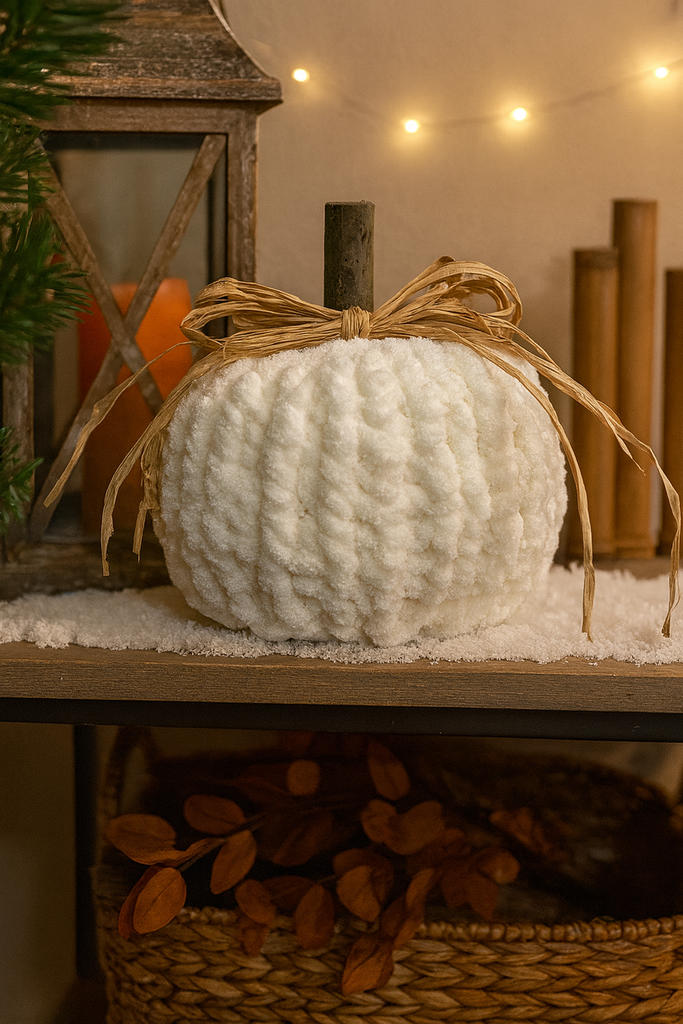 Hand-Knit cream pumpkin placed on a shelf with a warm, cozy background.